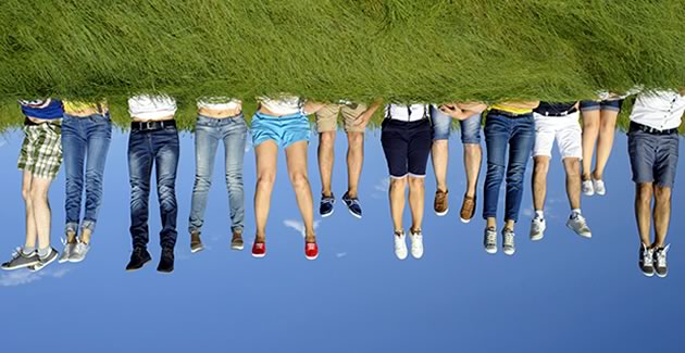 Stock image of people laying on the grass upsidown